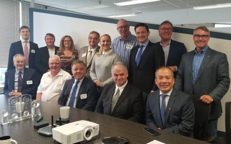 A group of well dressed people around a boardroom table