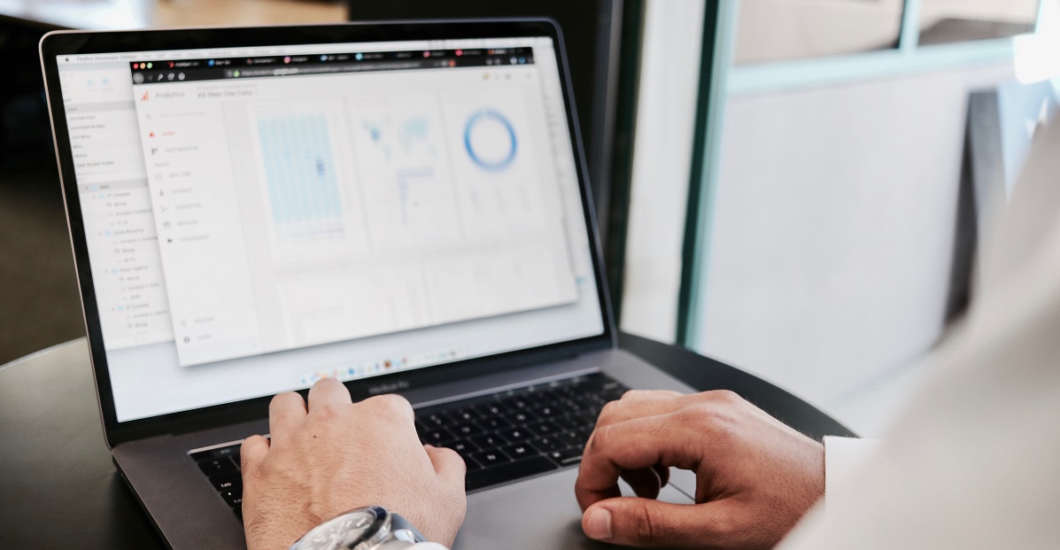 A closeup of someone typing on a computer showing charts