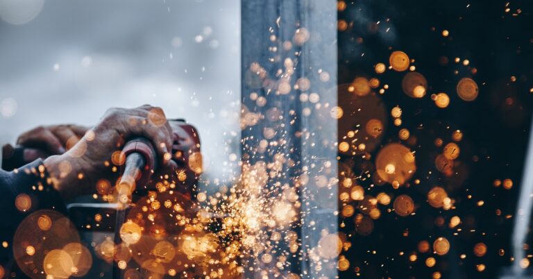 A closeup of a welder with sparks flying