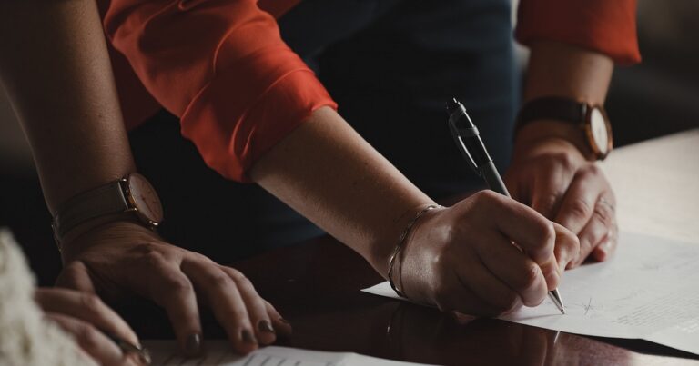 Close up of someone signing a document