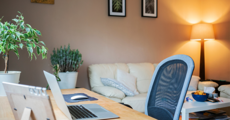 An office setup with desk chair and couch in the background
