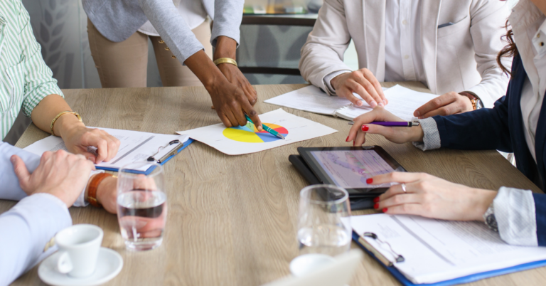 A close up of several people around a table with documents