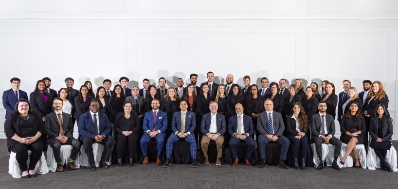 A group of professionally dressed men and women posing for a group photo